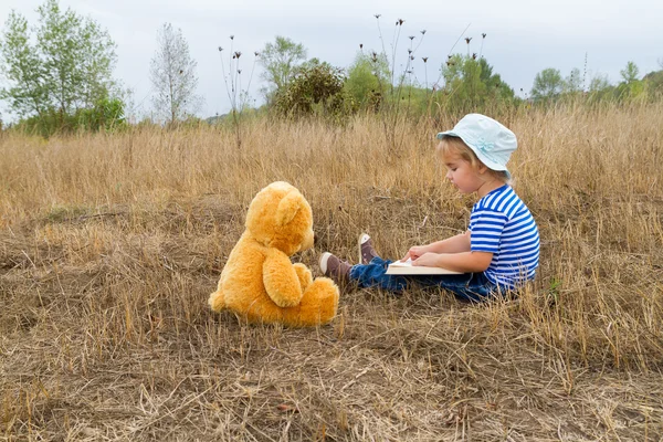 Carino ragazza lettura libro orsacchiotto — Foto Stock