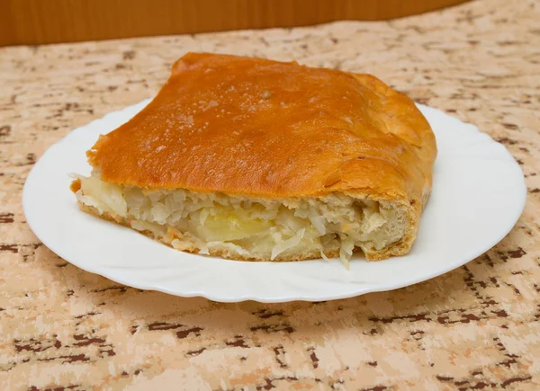 Pedaço da torta com batatas e repolho no prato . — Fotografia de Stock