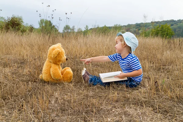 Carino ragazza lettura libro orsacchiotto — Foto Stock