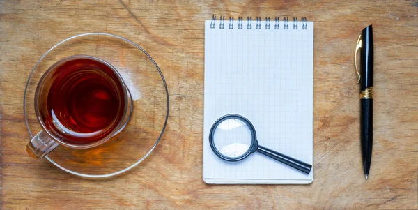 Malý notebook s šálkem čaje, přilepit na rustikální dřevěné backgro — Stock fotografie