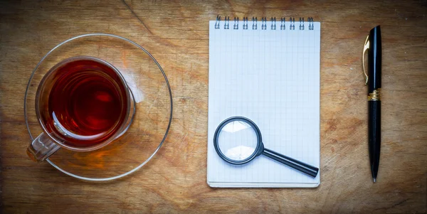 Malý notebook s šálkem čaje, přilepit na rustikální dřevěné backgro — Stock fotografie