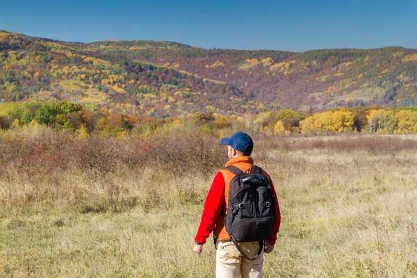 Male tourist with backpack sotret on the horizon in autumn — Stock Photo, Image