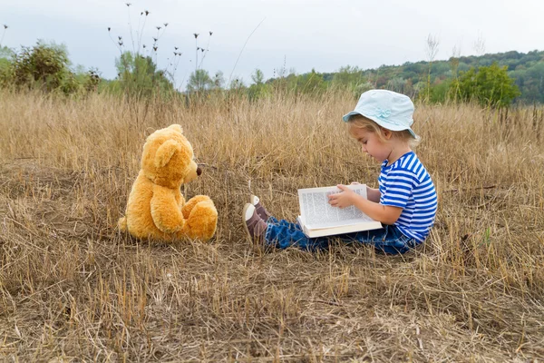 Carino ragazza lettura libro orsacchiotto — Foto Stock