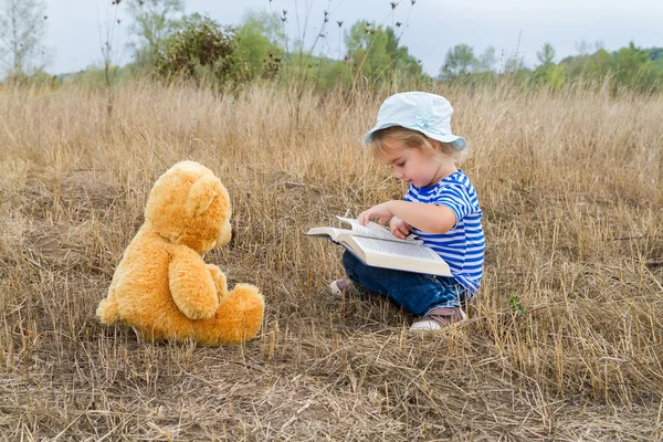 Słodkie dziewczyny czytanie książki pluszowego misia — Zdjęcie stockowe