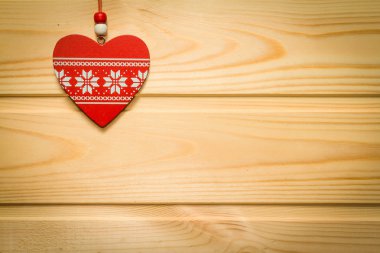 Ahşap kırmızı kalp bir doğal ahşap arka plan üzerinde askıya alındı. Valentin