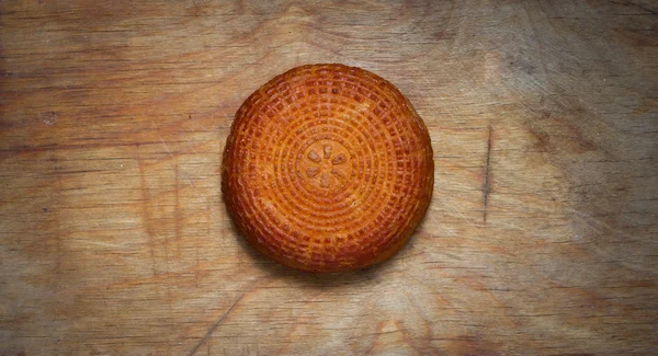 Home smoked rustic cheese on kitchen board. — Stock Photo, Image