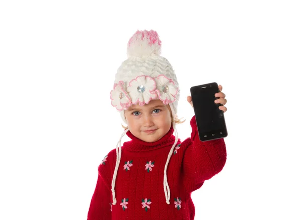 Niña con sombrero caliente y un suéter rojo muestra teléfono inteligente —  Fotos de Stock