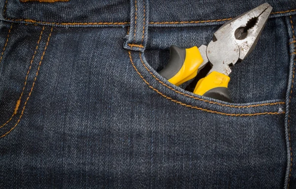 Alicates con asa amarilla en un bolsillo de jeans. antecedentes . —  Fotos de Stock