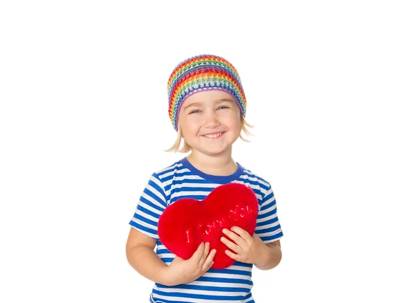 Menina segurando um brinquedo coração vermelho . — Fotografia de Stock