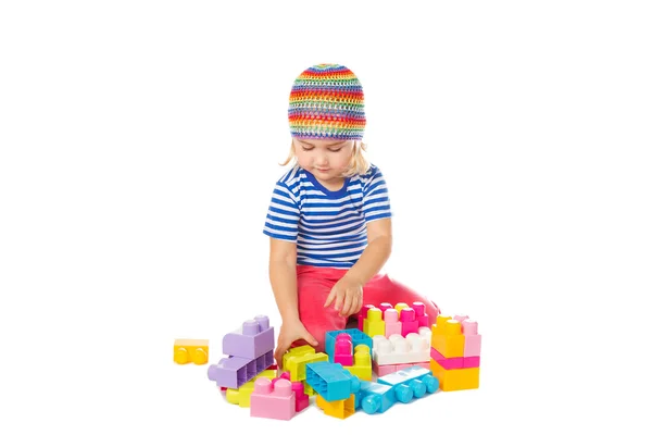 Niña en una camisa colorida jugando con juguete de construcción b — Foto de Stock