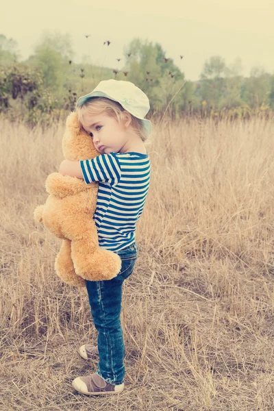 Carino bambina abbracciare un grande orsacchiotto — Foto Stock