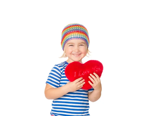 Menina segurando um brinquedo coração vermelho . — Fotografia de Stock