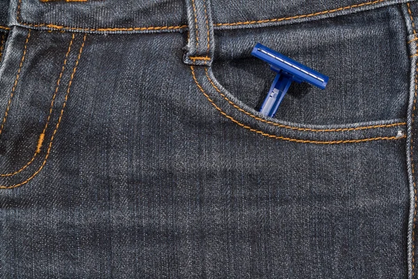 彼のポケットのジーンズにブルーの使い捨てカミソリ。バック グラウンド. — ストック写真
