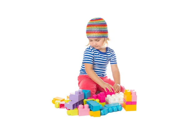 Niña en una camisa colorida jugando con juguete de construcción b — Foto de Stock