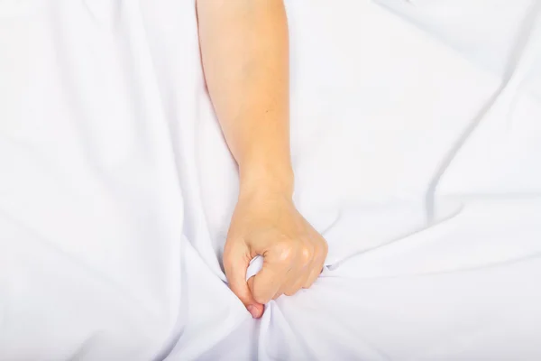 Mano femenina tirando de sábanas blancas en éxtasis — Foto de Stock