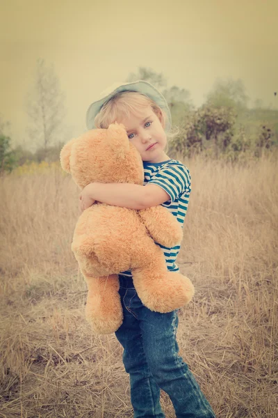 Petite fille mignonne embrassant un gros ours en peluche — Photo
