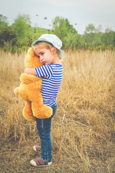 Carino bambina abbracciare un grande orsacchiotto — Foto Stock