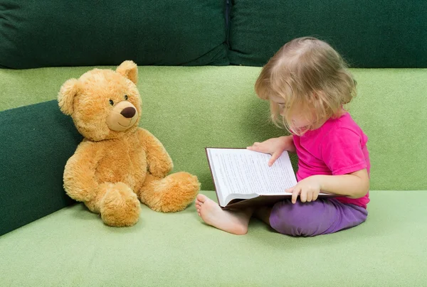 Kislány olvasó egy könyv mackó. — Stock Fotó