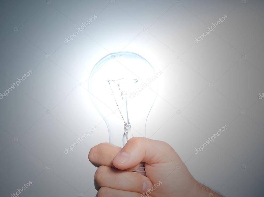 Hand holding an incandescent light bulb