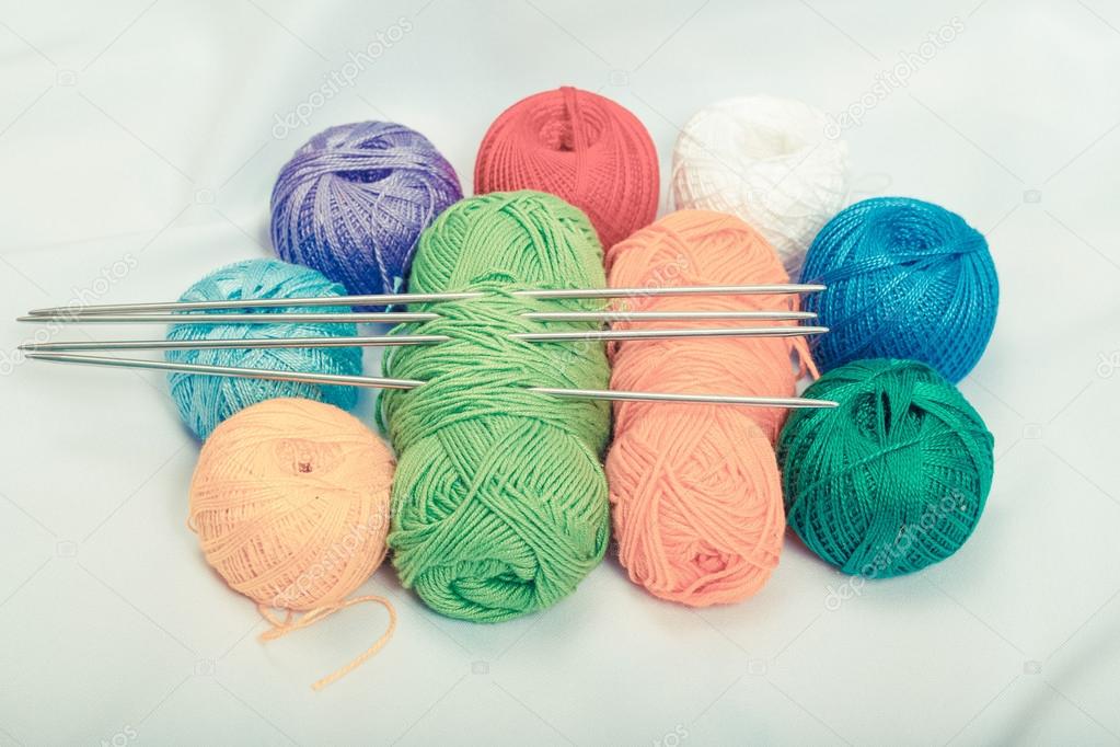 Colored balls of yarn, wool on white fabric.
