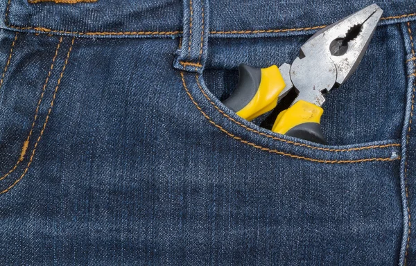 Alicates con asa amarilla en un bolsillo de jeans. antecedentes . —  Fotos de Stock