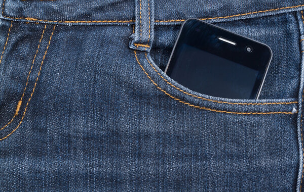 Black smartphone in your pocket jeans. background.