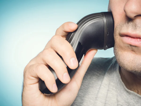 Man shaving his beard off with an electric shaver — Stock Photo, Image