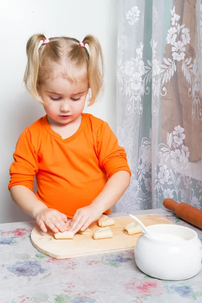 Kleines Mädchen macht Teig in der Küche. — Stockfoto