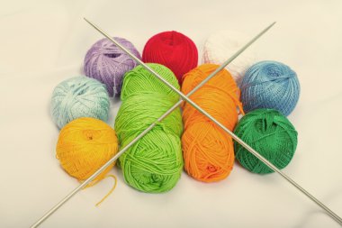 İplik, beyaz kumaş üzerine yün renkli toplar.