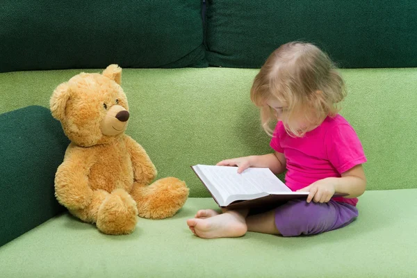 Niña leyendo un libro Osito de peluche . — Foto de Stock