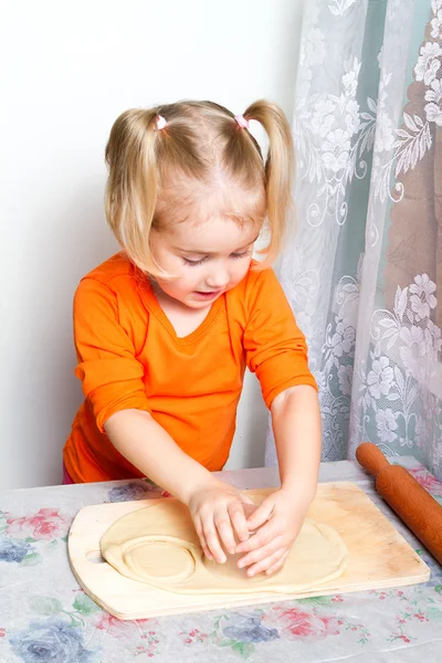 Kleines Mädchen macht Teig in der Küche. — Stockfoto