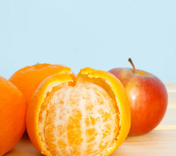 Mandarinen und Apfel auf Holztisch — Stockfoto