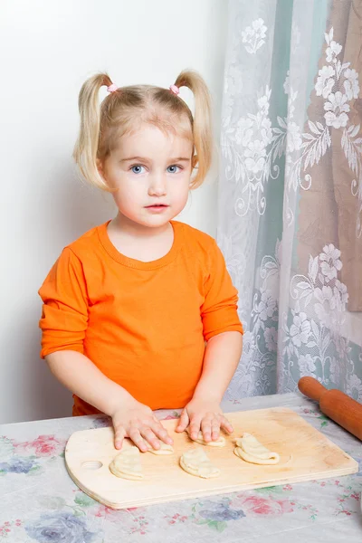 Kleines Mädchen macht Teig in der Küche. — Stockfoto