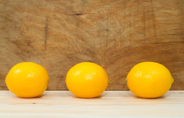 Ярко-желтые сочные лимоны на столе . — стоковое фото