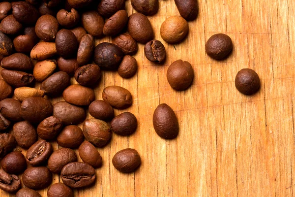 Grãos de café em fundo de madeira — Fotografia de Stock