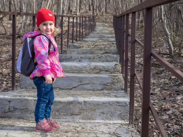 Kleines Mädchen mit einem Rucksack die Treppe hinauf. — Stockfoto