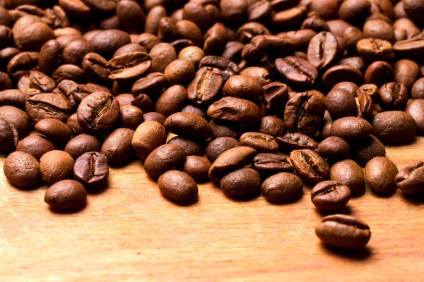 Grãos de café em fundo de madeira — Fotografia de Stock