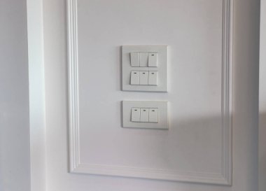 İşaret parmakları ahşap duvardaki ışık düğmesini açıyor ya da kapatıyor. 