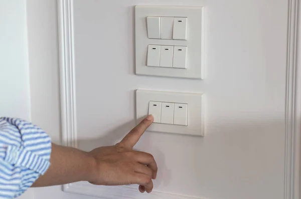 Close Forefingers Turning Turning Light Switch Wooden Wall — Stock Photo, Image