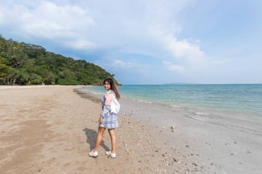 Kendini denizdeki güneş ışınlarından korumak için giyinmiş bir kadın..