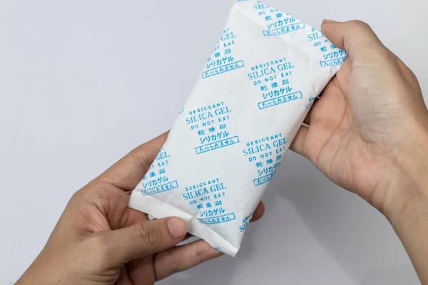 Pakette Desiccant Silica var. Yakından bak. Silika kristallerine gömülü bir paket silis jeli. Önüne Çince, Japonca ve İngilizce yazma..