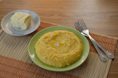 Mısır lapası ve tereyağı masada. Geleneksel ev yemeği. Masa takımı mutfak masasında.. 