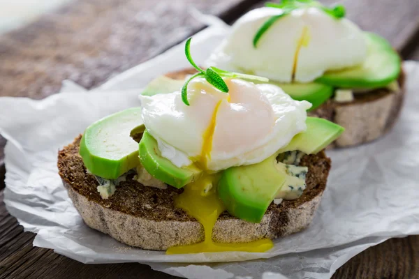 Matig smörgås med avocado grönmögelost och pocherat ägg — Stockfoto