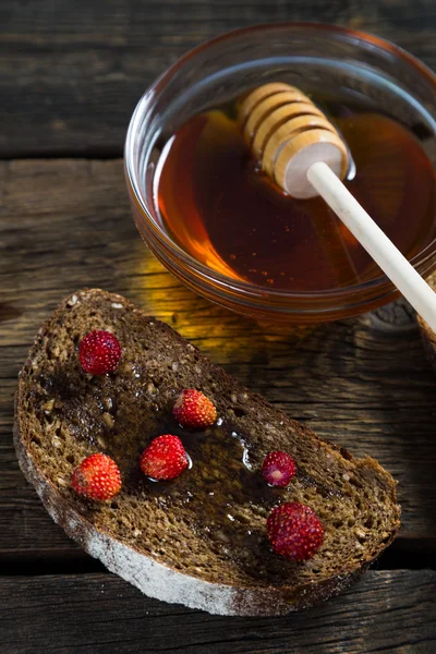 Fullkornsbröd med honung och jordgubbar — Stockfoto