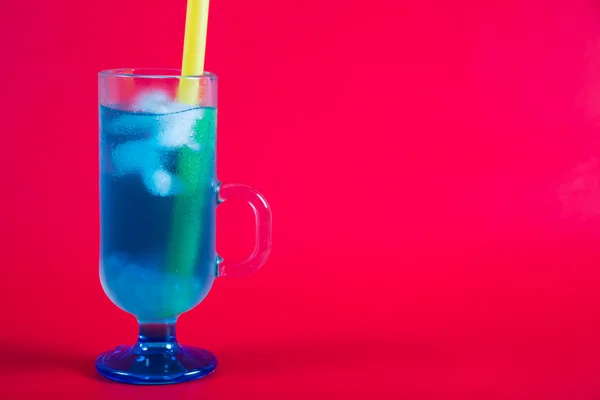 Refrescante cóctel azul sobre un fondo rojo —  Fotos de Stock