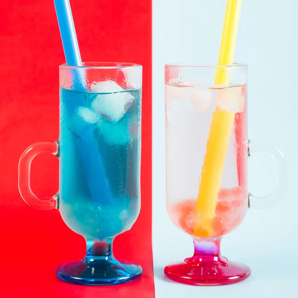 Quelques cocktails rafraîchissants sur fond rouge-bleu — Photo