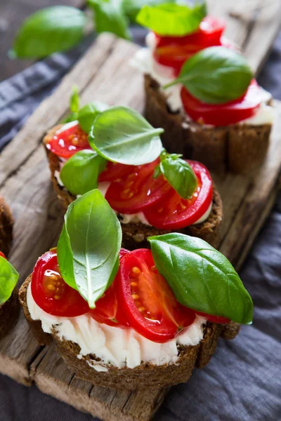 Bruschetta cu cremă de brânză roșii cherry și busuioc — Fotografie, imagine de stoc