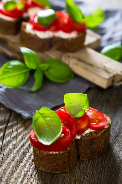 Bruschetta cu cremă de brânză roșii cherry și busuioc — Fotografie, imagine de stoc