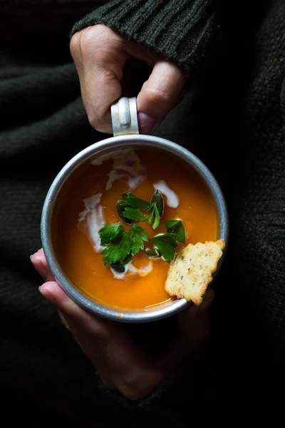 Coupe avec soupe à la crème de carotte dans les mains d'une fille — Photo