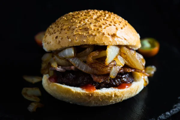 Big burger with beef, bacon and fried onions